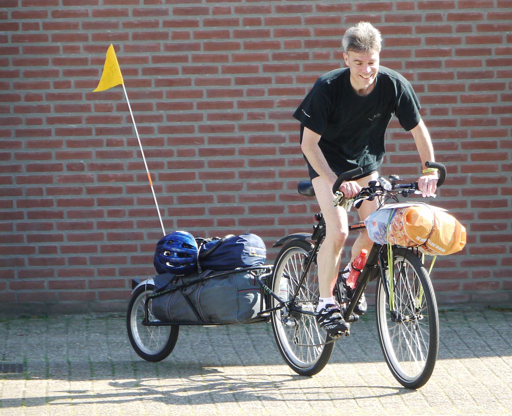 Foto van Michel op een fiets met een eenwielig bagagewagentje