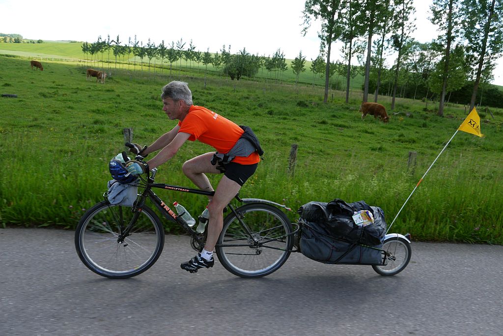 Foto van Michel op zijn fiets-met-aanhanger, bezig aan een beklimming